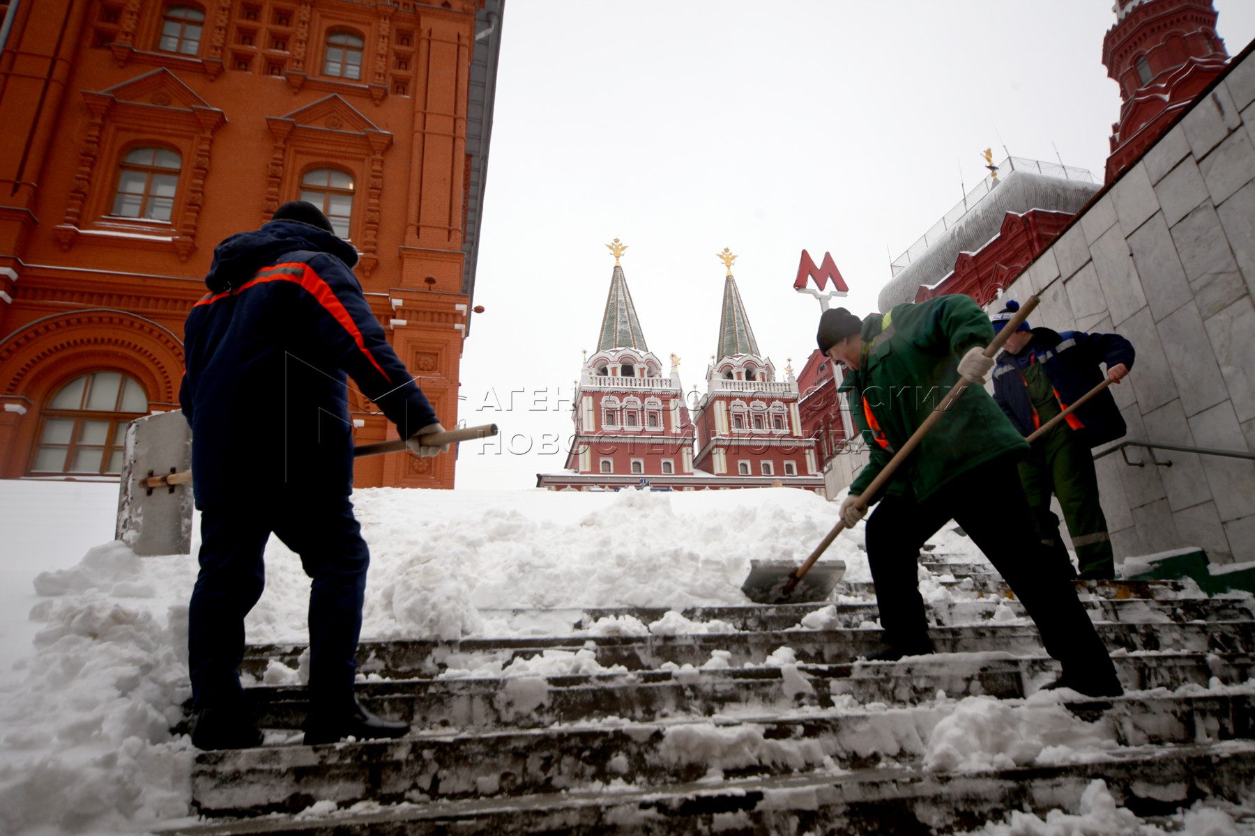 Очистить москву. Дворники и народ в снегопад на красной площади.